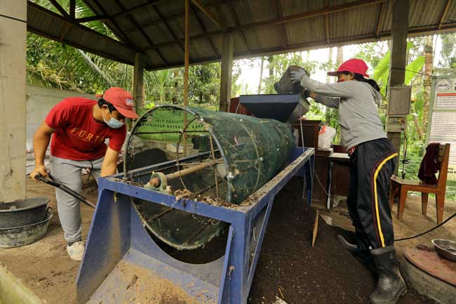 Proses pengayakan untuk membuat pupuk kompos di TPS3R Desa Taro, Gianyar, Bali. (GATRA/Jongki Handianto)