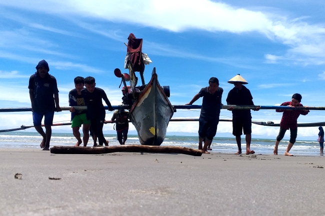 Para nelayan di Kota Padang sedang maelo pukek secara bergotong-royong usai melaut. (GATRA/Wahyu Saputra)